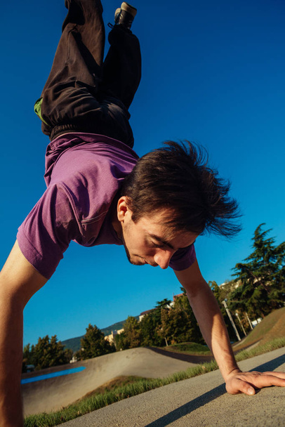 Молодой спортсмен делает паркур и атлетические трюки
 - Фото, изображение