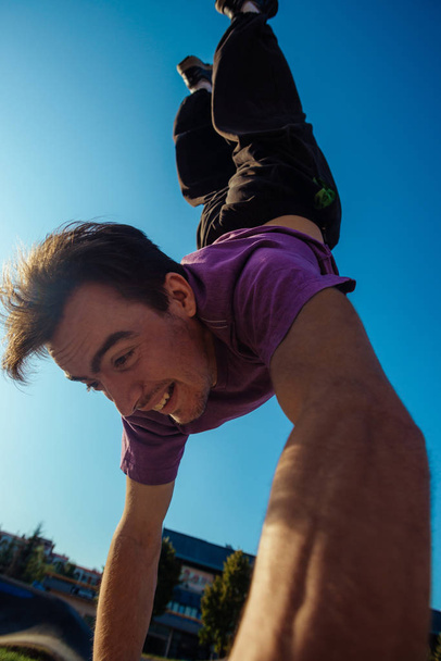 Parkour moves performed by an acrobatic guy at the local skate playground - Foto, Bild