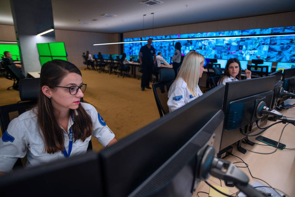 guardas de segurança do sexo feminino trabalhando em computadores enquanto sentado na sala de controle principal - Foto, Imagem