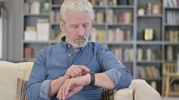 Portrait of Serious Old Man using Smartwatch - Filmati, video