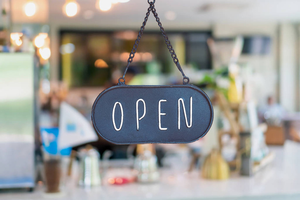 A business sign that says Open on cafe or restaurant hang on door at entrance. Vintage color tone style. - Foto, Imagem