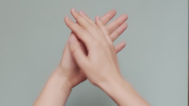 Close up shot of clapping female hands isolated on blue-grey background copy text space. Faceless woman applauding indoors macro palms slow motion. Body language symbols signs - Footage, Video