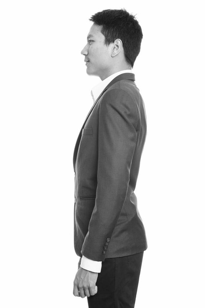Προβολή προφίλ του νεαρού Ασιάτη επιχειρηματία που φοράει κοστούμι - Φωτογραφία, εικόνα
