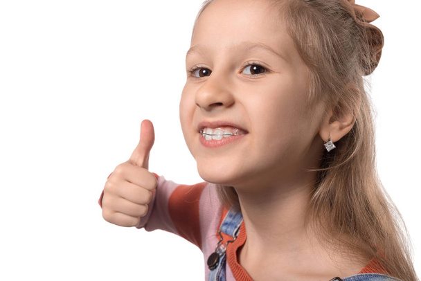 Kislány fogszabályozó készülékkel elszigetelt fehér backgr - Fotó, kép