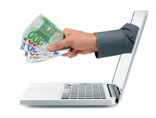Διαδίκτυο κέρδη έννοια - χέρι με χρήματα που βγαίνει από την οθόνη του φορητού υπολογιστή - Φωτογραφία, εικόνα