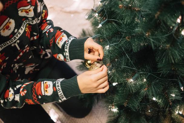 Przycięta dziewczyna powiesić Boże Narodzenie bal na drzewie - Zdjęcie, obraz