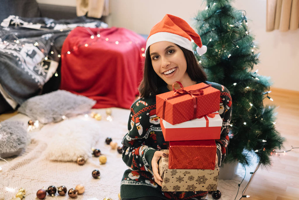 Smiling woman with gifts looking at camera - Foto, imagen