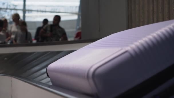 Suitcase and a bag are moving along the conveyor belt at the airport. Close-up. - Footage, Video