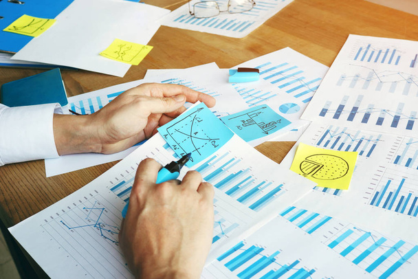 Auditor está verificando informe financiero con gráficos y gráficos de negocios
. - Foto, imagen