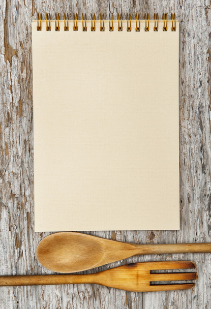 Кухонные принадлежности и бумажная спираль ноутбука на старом дереве
 - Фото, изображение