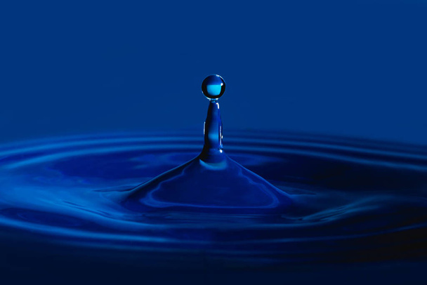 spruzzi di goccia d'acqua in una tazza di vetro di colore blu
 - Foto, immagini