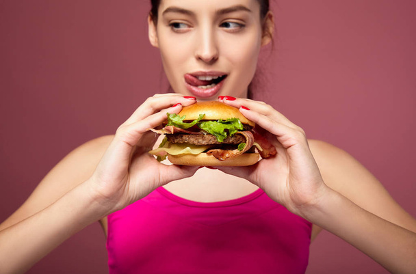 Hungry woman holding big burger. - Фото, изображение