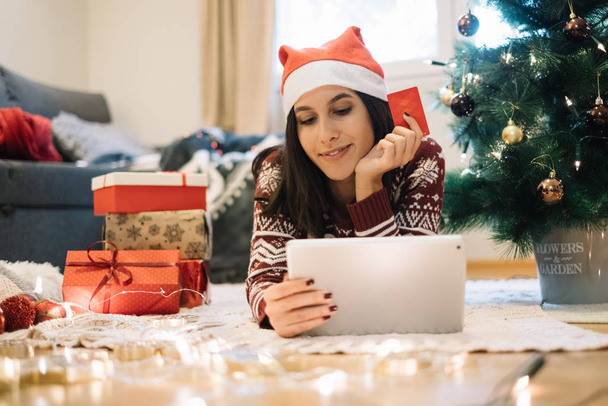 Young woman enjoying shopping online for Christmas - Fotó, kép
