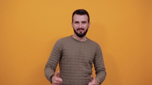 alegre homem sobre isolado laranja backgroundholding polegares para cima, sorrindo
 - Filmagem, Vídeo