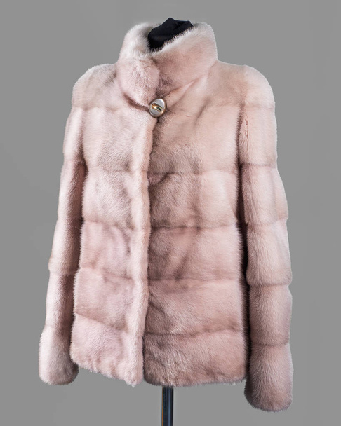 Short blonde mink fur coat, lady driver, made of transverse bands. Horizontal frame - Foto, imagen