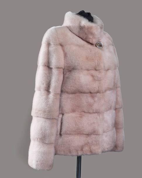 Short blonde mink fur coat, lady driver, made of transverse strips, the side view. Horizontal frame - Foto, imagen