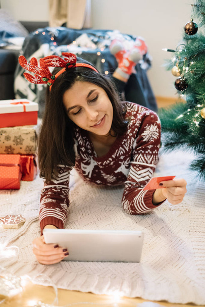 Girl ordering gifts online while lying on floor - Photo, Image