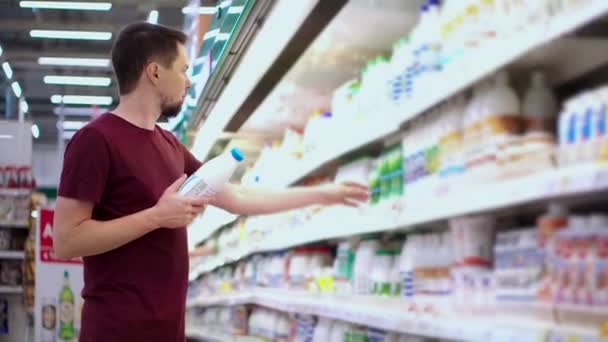 Άντρας που αγοράζει γαλακτοκομικά προϊόντα στο σούπερ μάρκετ - Πλάνα, βίντεο