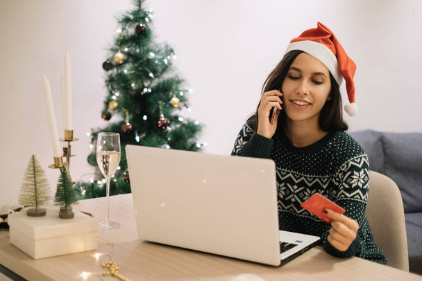 Girl buying gifts by phone in front of the laptop - Photo, image