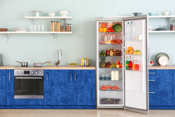 Abra o grande refrigerador com produtos no interior da cozinha
 - Foto, Imagem