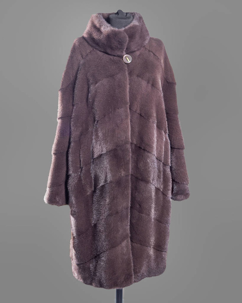 Mink coat em tons lilás-marrom, cortar listras oblíquas silhueta reta. Quadro horizontal
 - Foto, Imagem