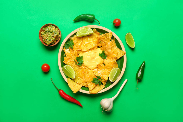Placa con sabrosos nachos y guacamole sobre fondo de color
 - Foto, imagen
