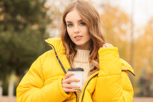 Portrait of stylish young woman with cup of coffee on autumn day - Fotoğraf, Görsel