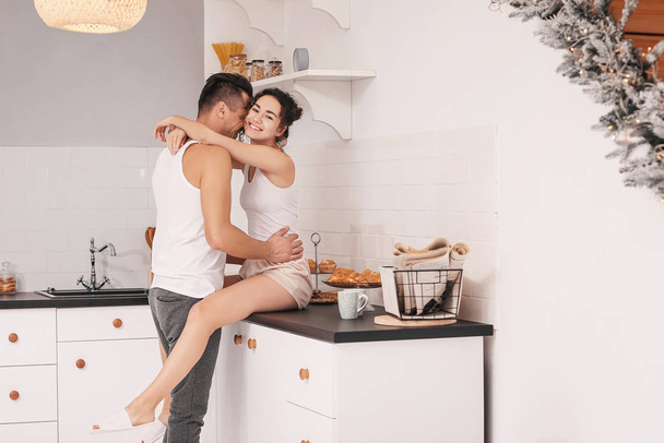 Happy young couple in kitchen at home - Фото, зображення