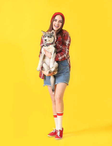 Stylish woman with funny husky puppy on color background - Photo, Image