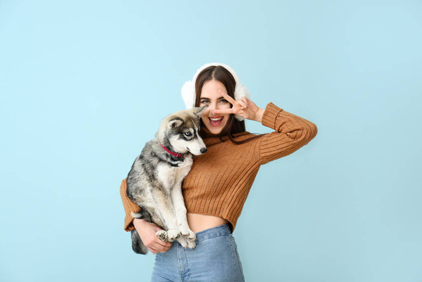 Cute woman with funny husky puppy on color background - Photo, image