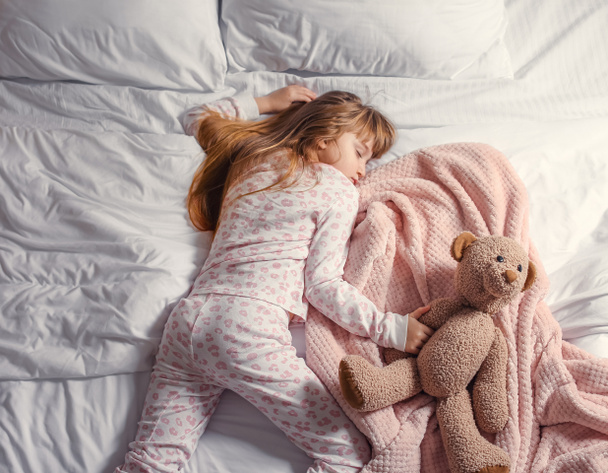 schattig klein meisje slapen in bed - Foto, afbeelding