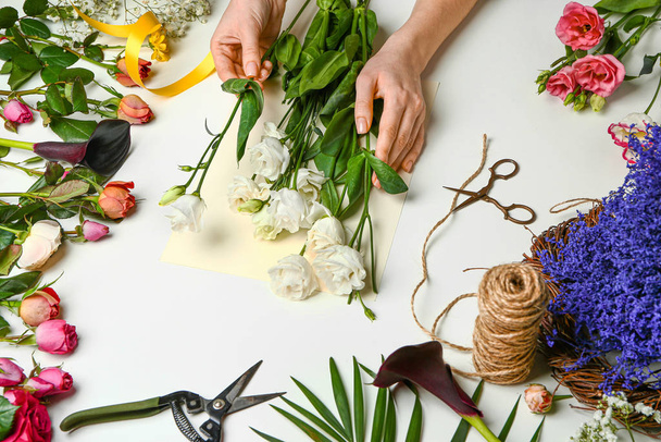 Blumenhändlerin macht schönen Strauß auf weißem Hintergrund - Foto, Bild