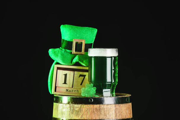 Bir kupa yeşil bira, Leprikon şapkası, takvim ve fıçı koyu arka planda. Aziz Patrick Günü kutlaması - Fotoğraf, Görsel