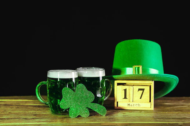 Green beer, calendar and Leprechaun's hat on table. St. Patrick's Day celebration - Photo, Image
