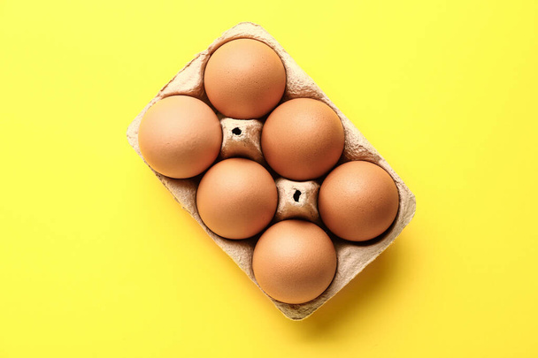 Package with fresh eggs on color background - Foto, imagen