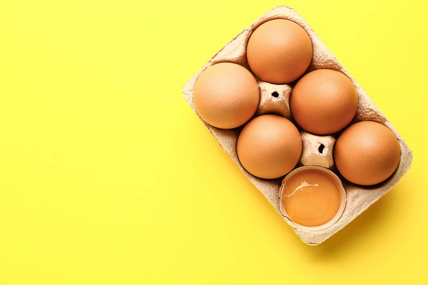 Пакет зі свіжими яйцями на кольоровому фоні
 - Фото, зображення
