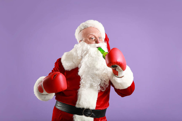 Funny drunk Santa Claus in boxing gloves on color background - Photo, Image