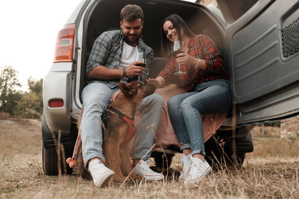 Casal viajante feliz juntos Aproveitando viagem de carro com seu cão, Conceito de férias, Férias fora da cidade
 - Foto, Imagem