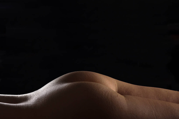curves of a woman lying on black background - Zdjęcie, obraz