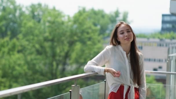 Nyugodt fiatal nő az erkélyen - Felvétel, videó