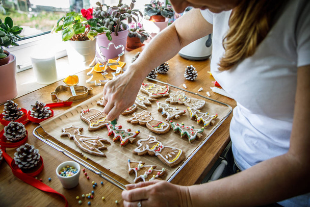Woman making Christmas gingerbread cookies in kitchen  - Фото, изображение
