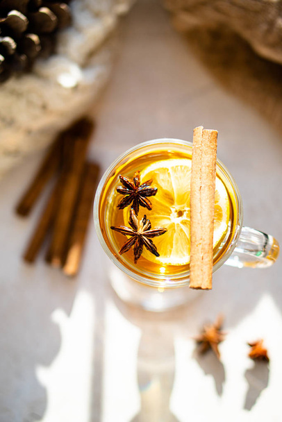 Hot winter drink with cinnamon and lemon on bright sunny day - Zdjęcie, obraz