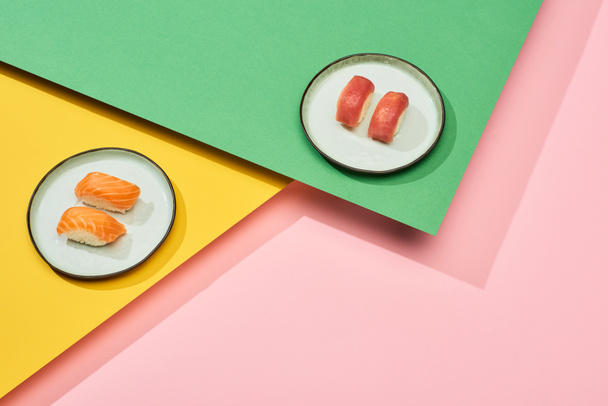 fresh nigiri with salmon and tuna on yellow, pink, green background - Foto, imagen