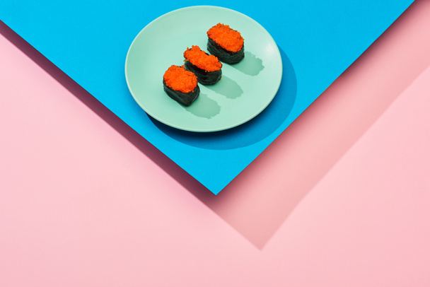 fresh nigiri with red caviar on blue, pink background - 写真・画像