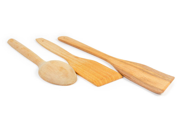 Dos espátulas de cocina de madera y cuchara sobre fondo blanco de cerca
 - Foto, Imagen