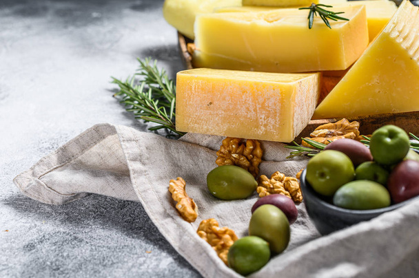 Cheese plate served with grapes, crackers, olives and nuts. Assorted delicious snacks. Gray background. Top view. Space for text - Fotografie, Obrázek