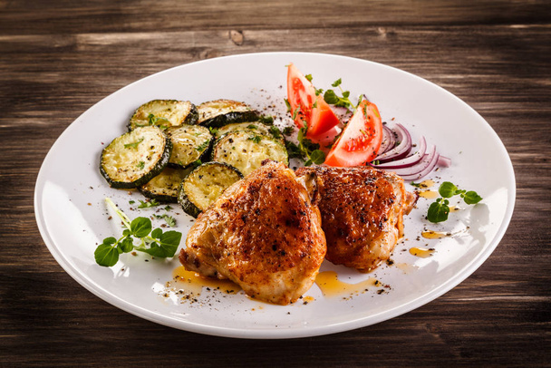 Fried chicken thighs with zucchinis and fresh vegetables - Fotó, kép