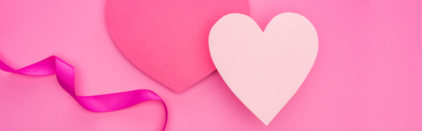 bovenaanzicht van lege papieren harten met lint geïsoleerd op roze, panoramische opname - Foto, afbeelding