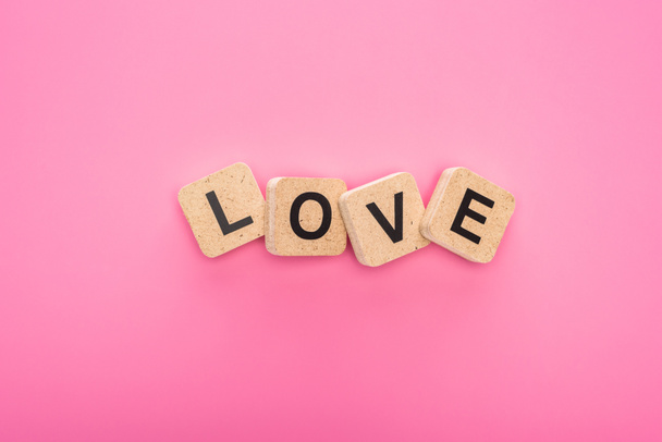 top view of love lettering on wooden cubes isolated on pink - Photo, Image