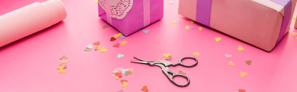 valentines confetti, scissors, wrapping paper, gift boxes on pink background, panoramic shot - Photo, Image
